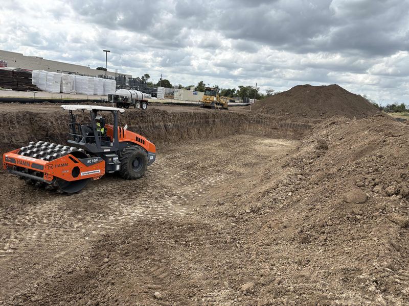 Padfoot roller compacting the bottom of a wide commercial excavation