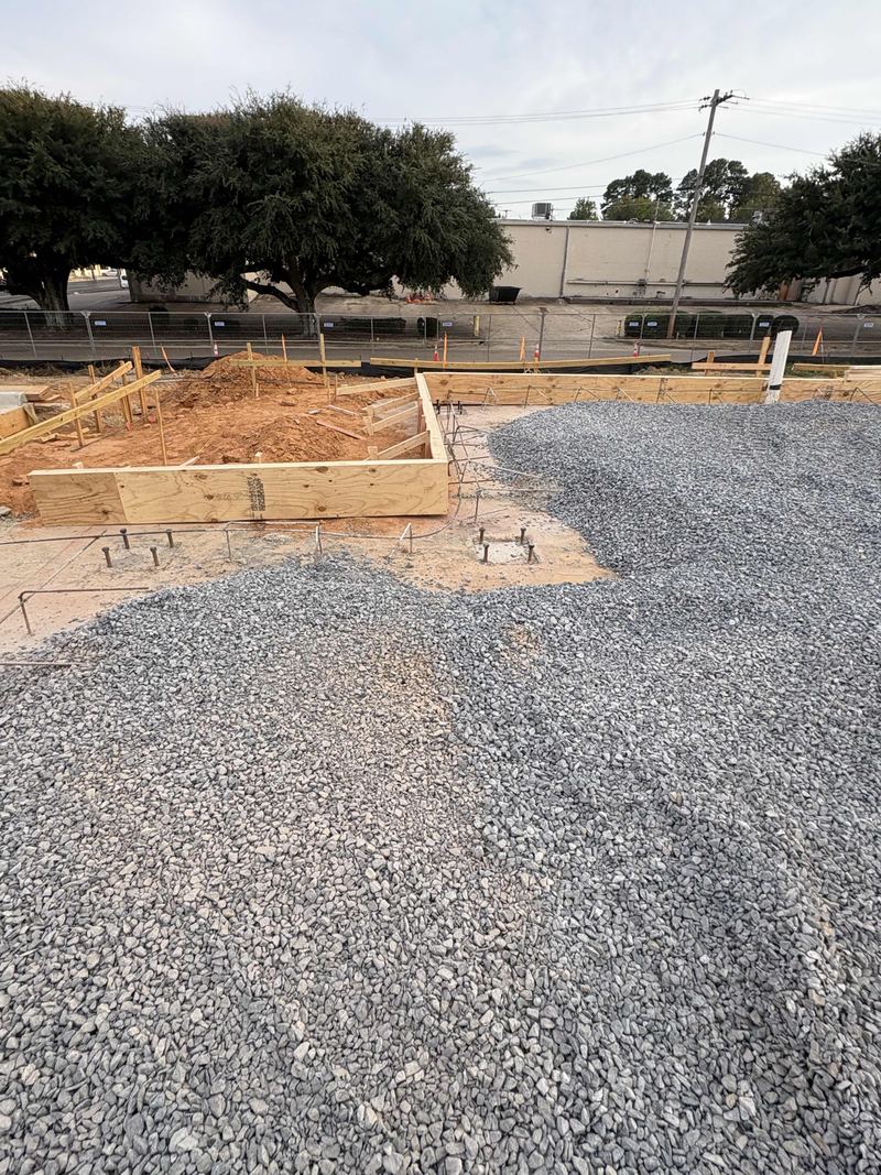 Crushed stone spread inside the foundation forms of a commercial building pad