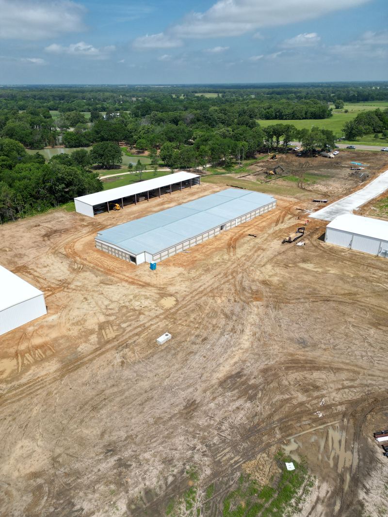 Aerial view of a graded commercial site with metal buildings going up, near Paris, TX