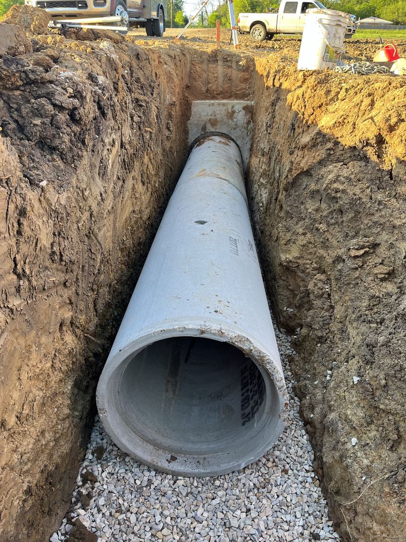 Large concrete pipe set on gravel bedding in a trench